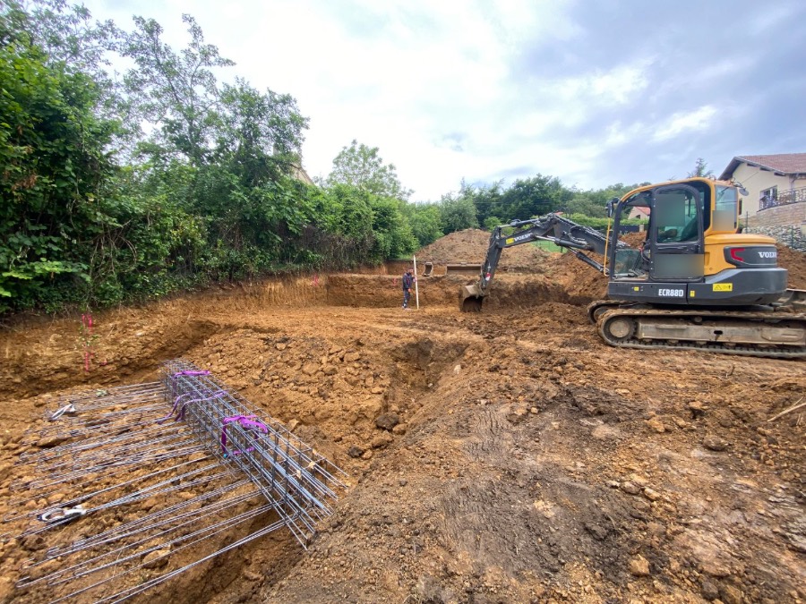 Terrassement du terrain : pelleteuse, fouilles et armatures des fondations
